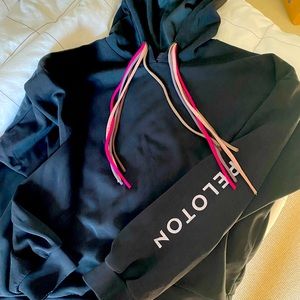 Womens Peloton hoodie with multi colored tie strings.